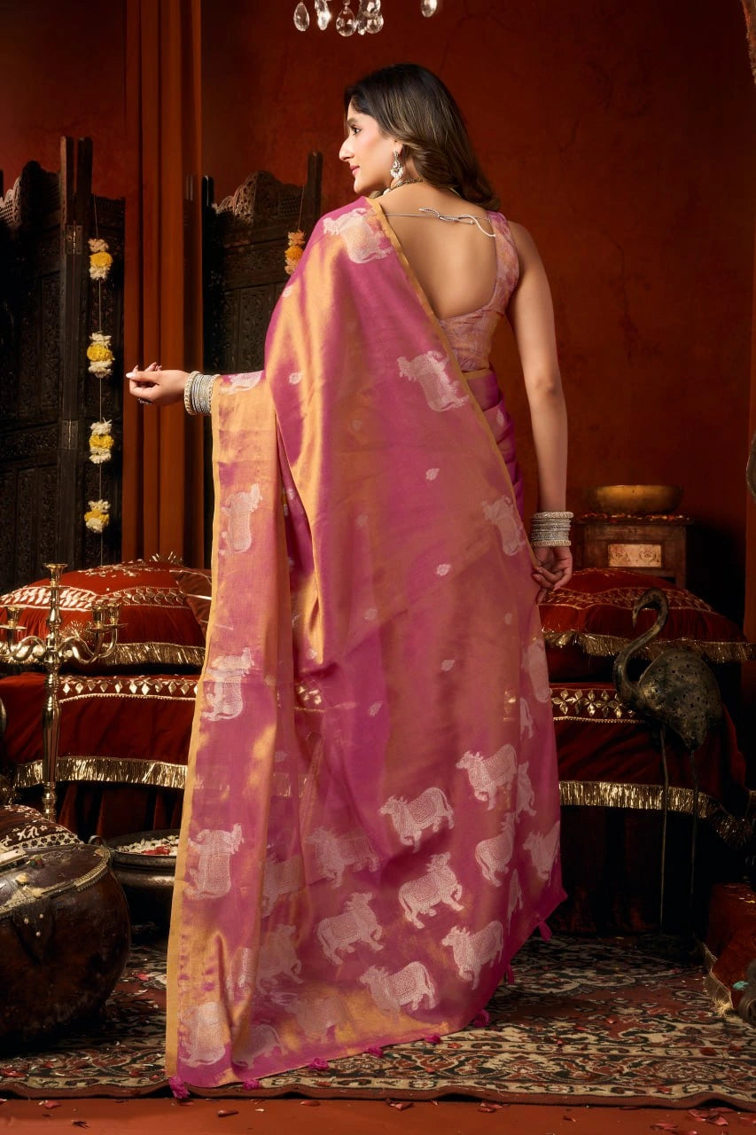 Woman in a pink saree with white patterns in a traditional setting